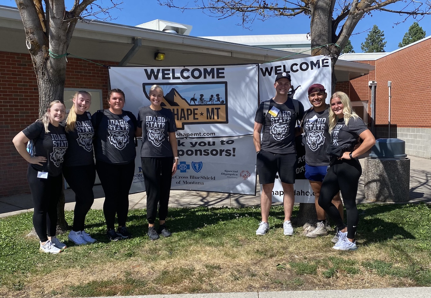 A group of students stand outside a building.