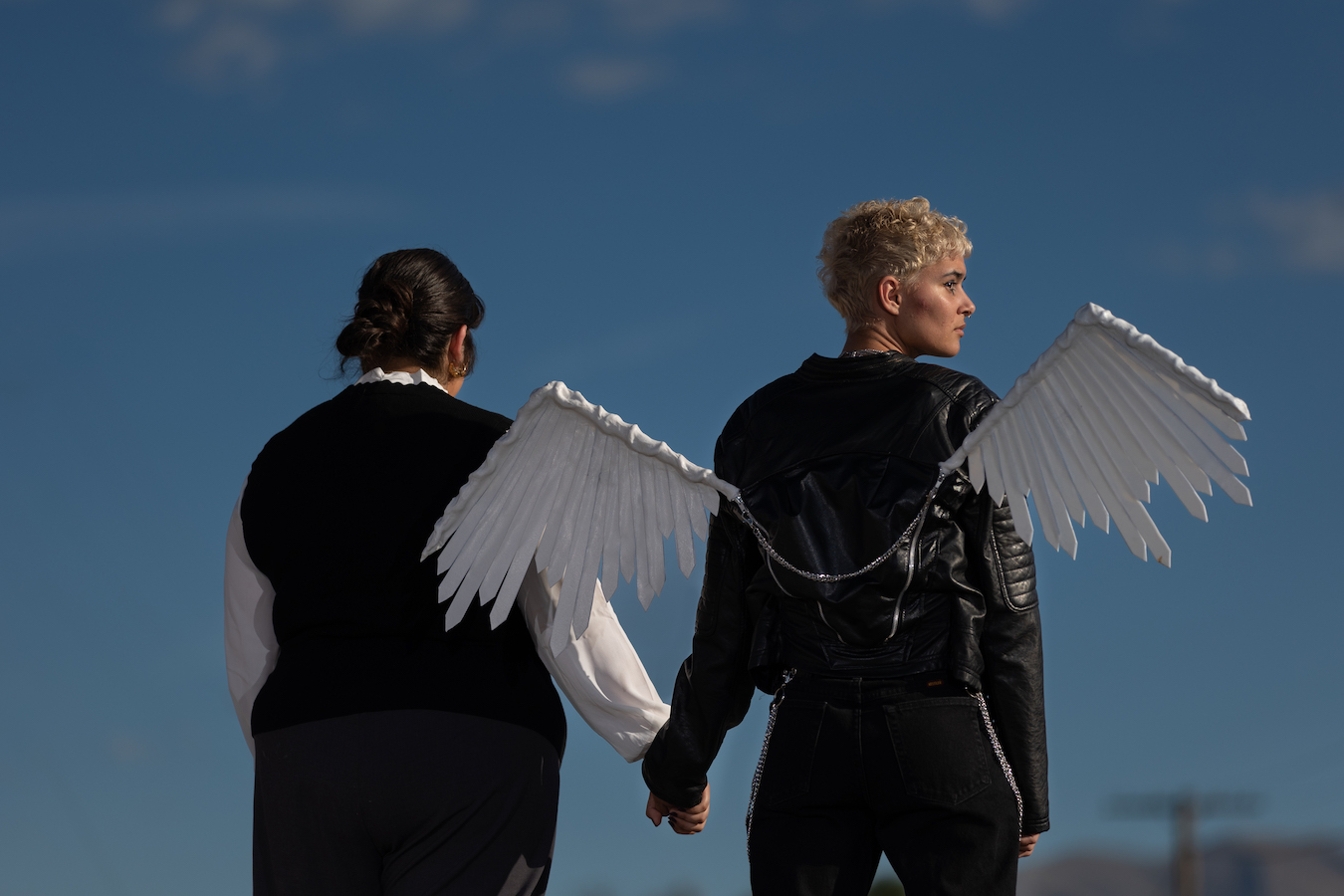 An angel and a man hold hands.