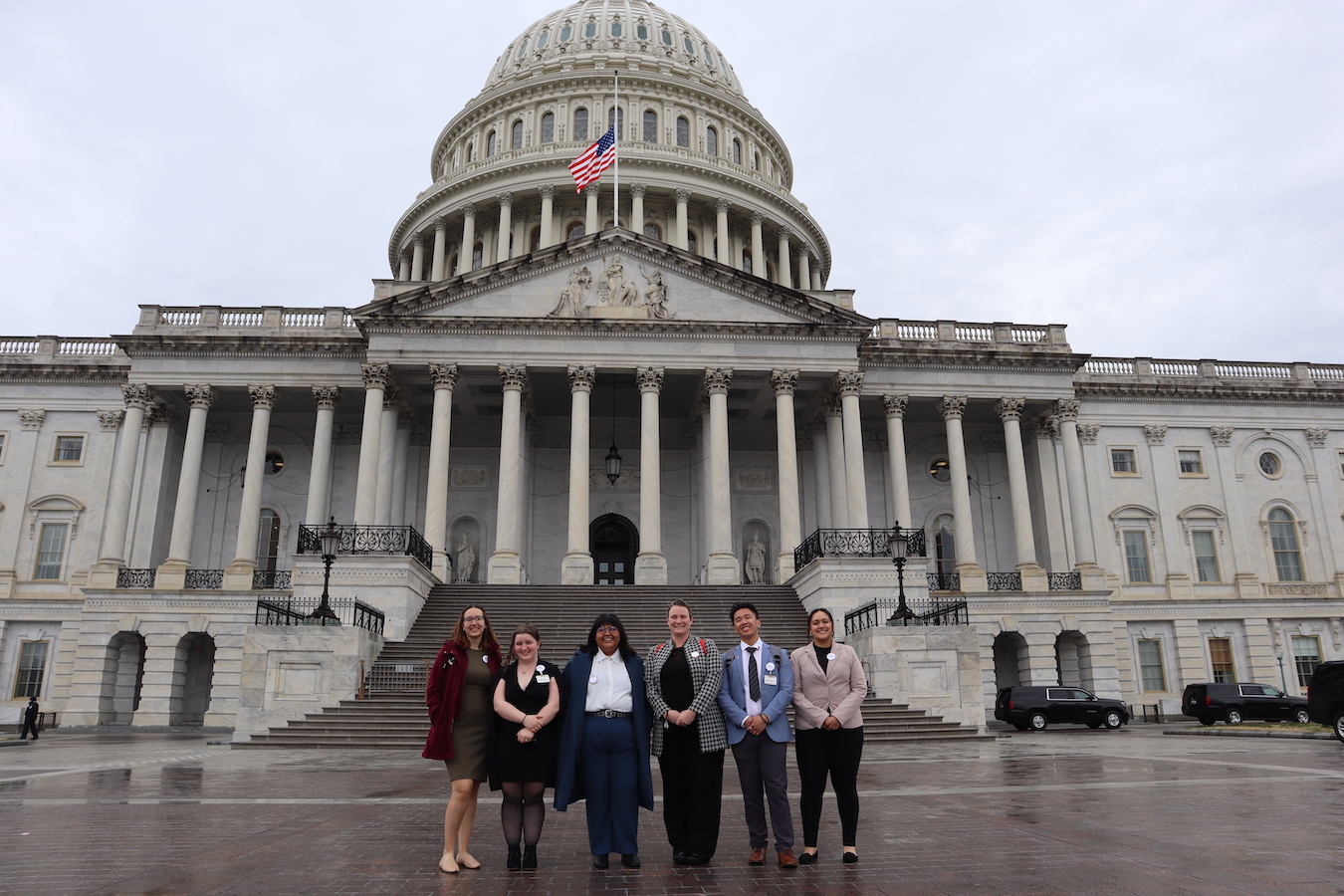 A group shot of employees in front of the U.S. Capitol