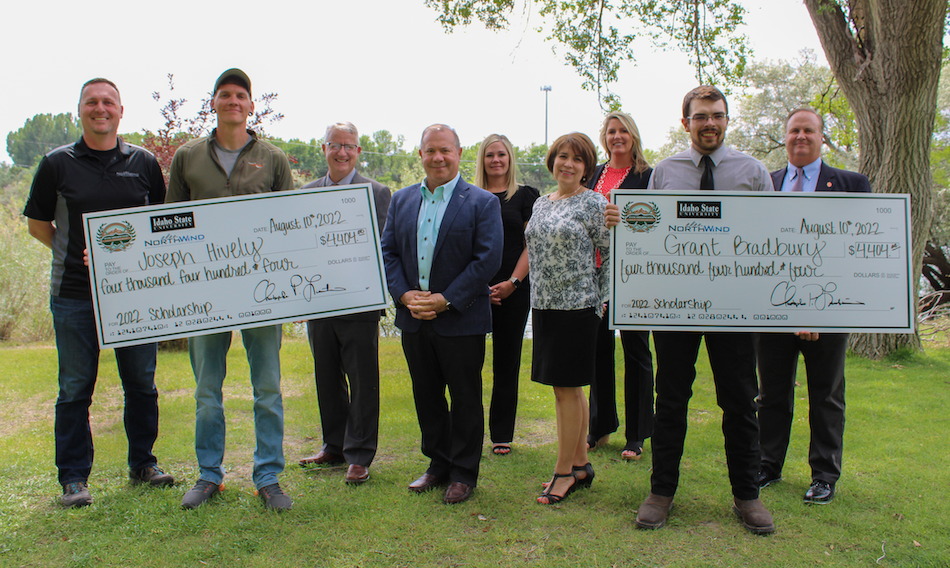 A group of people hold a large check