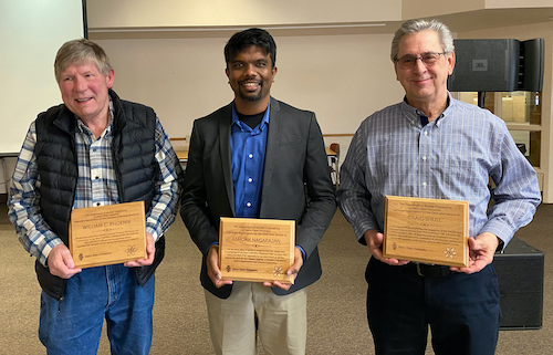 Three volunteers receive a plaque