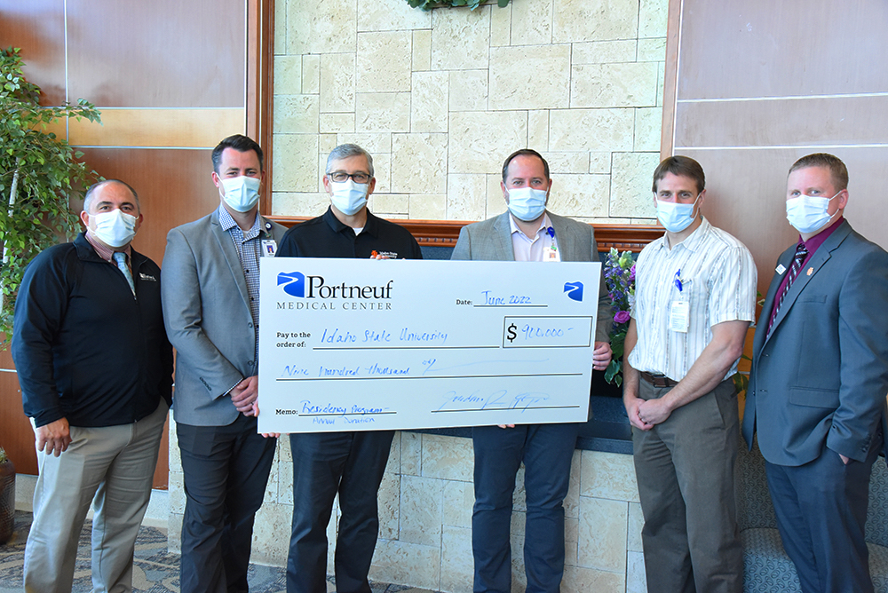 ISU and PMC representatives holding a giant check