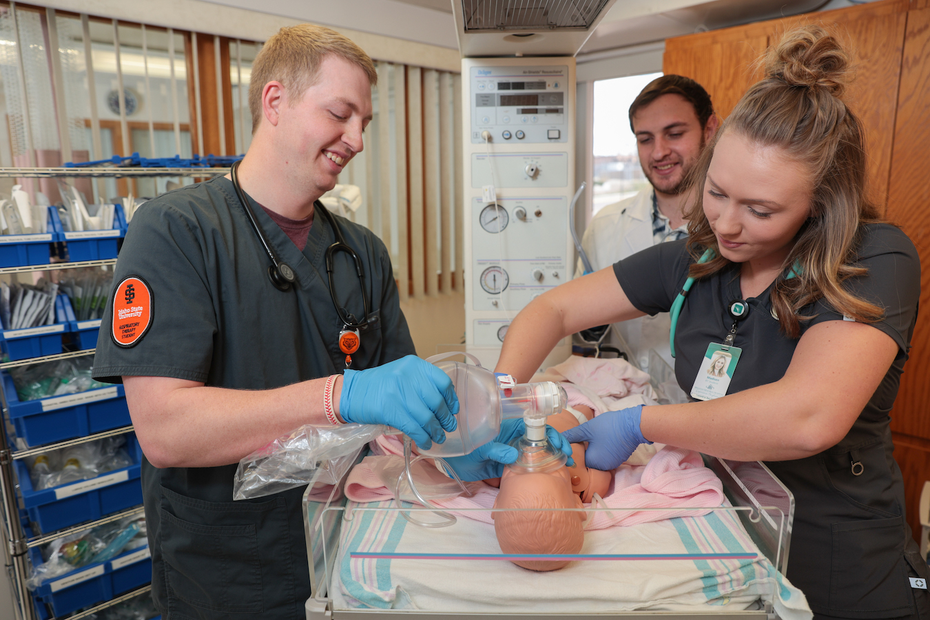 Three students practice CPR