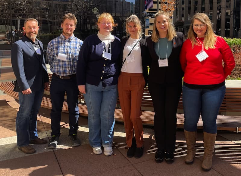 Five students pose for a photo at the conference