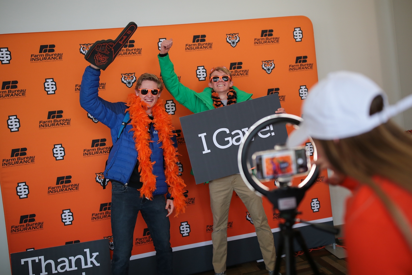 Two students hold up signs and cheer during Bengal Giving Day.