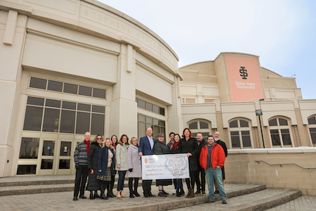 A group of people hold a check from Farm Bureau to Idaho State's Theatre Department