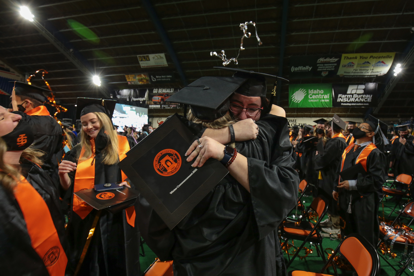 Two graduates hug at winter commencement ceremonies