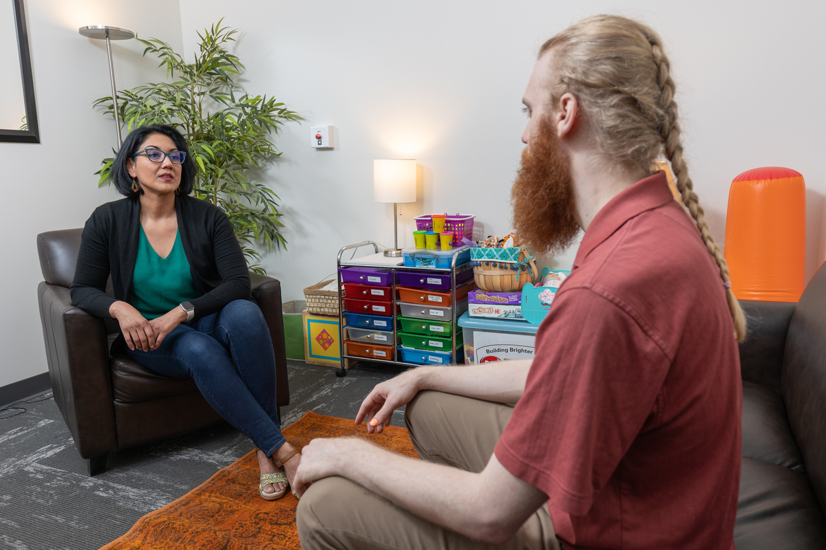 A man talks to a woman in a counseling office