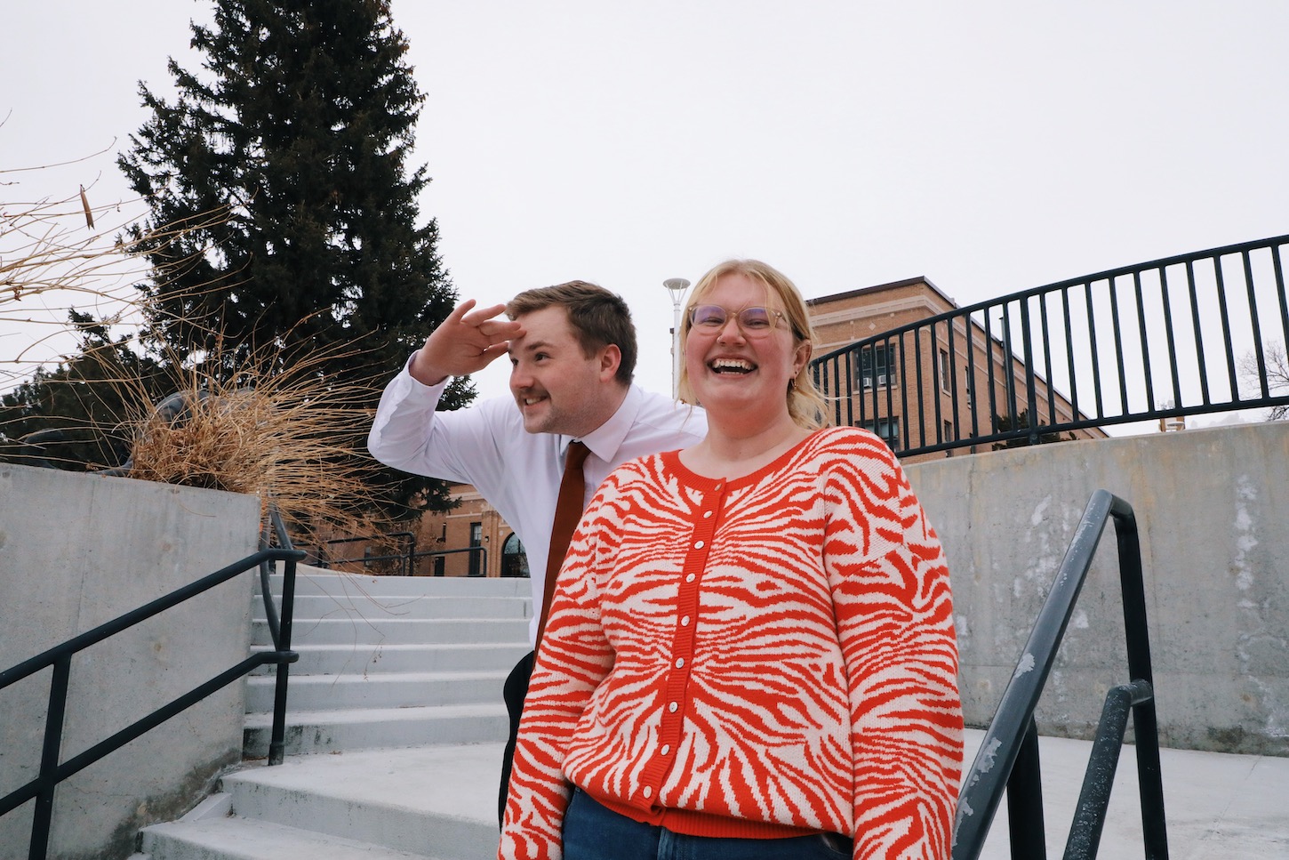 A man and a woman stand outside .