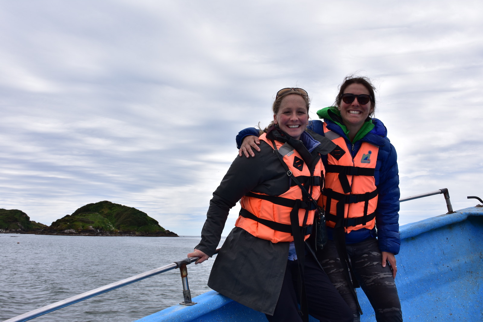 Two women in life jackets on a boat