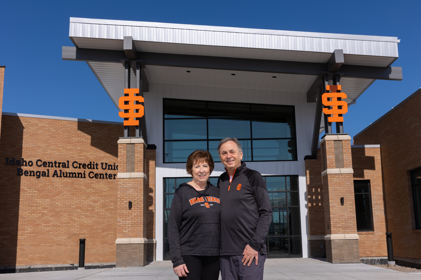 Rhonda an Pete Black stand in front of the Alumni Center
