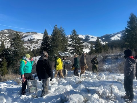 Students walk through the snow near solar panels