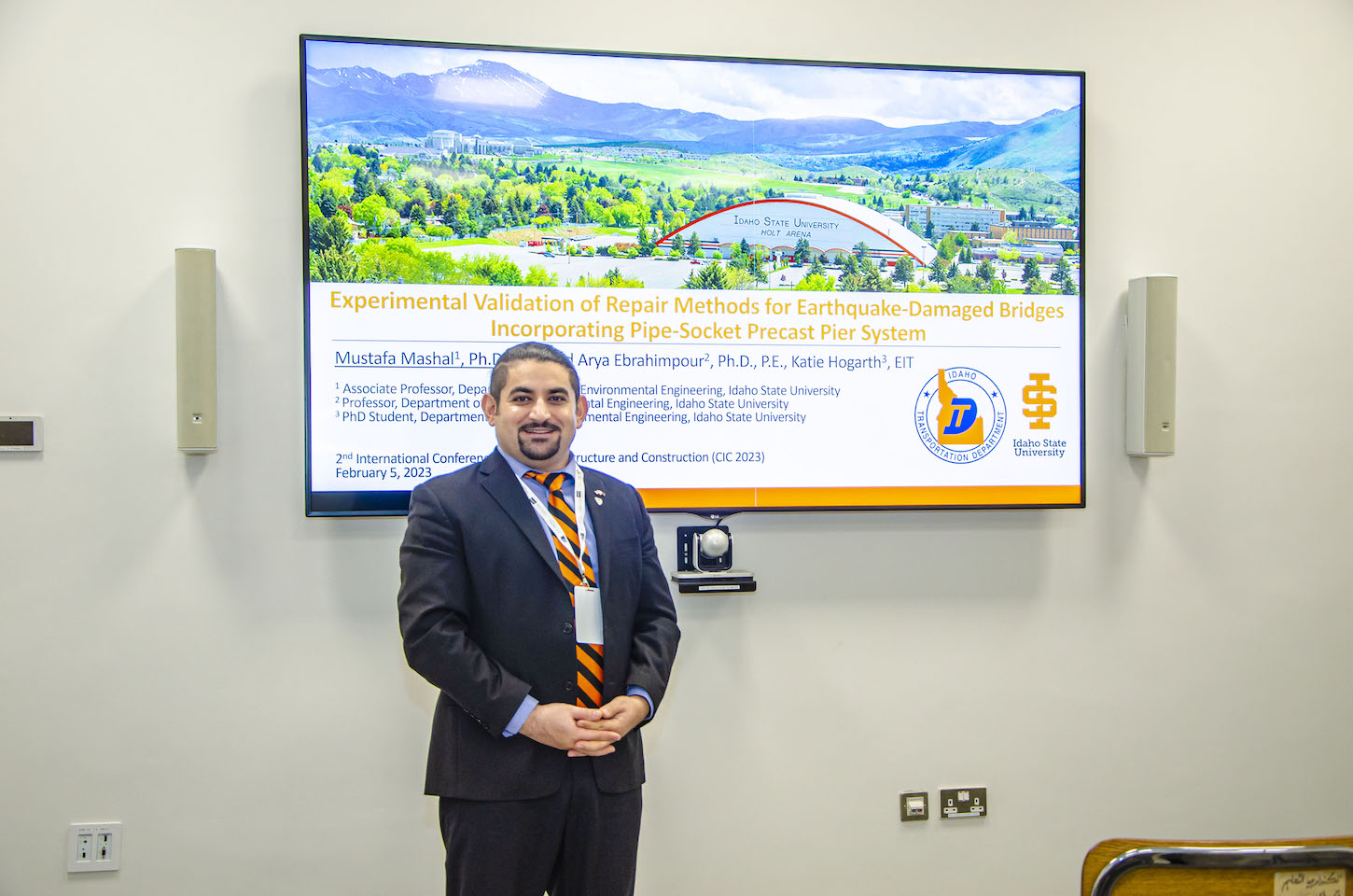 Mustafa Mashal stands near a poster.