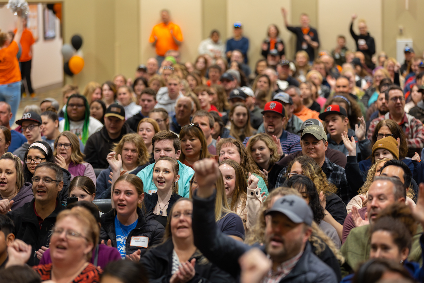 A crowd cheers in a room