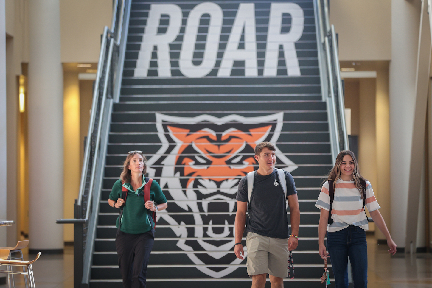 Two students walk down stairs