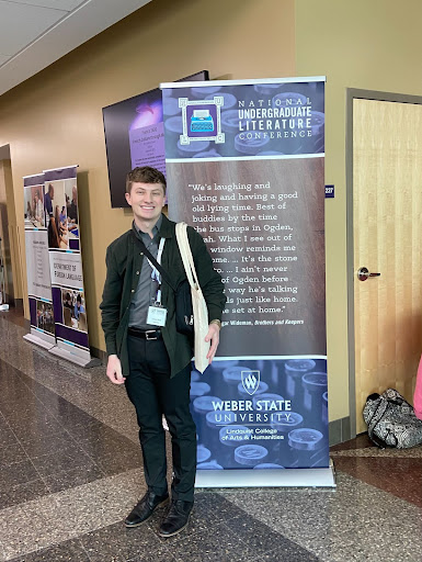 A man stands in front of a sign at a research conference