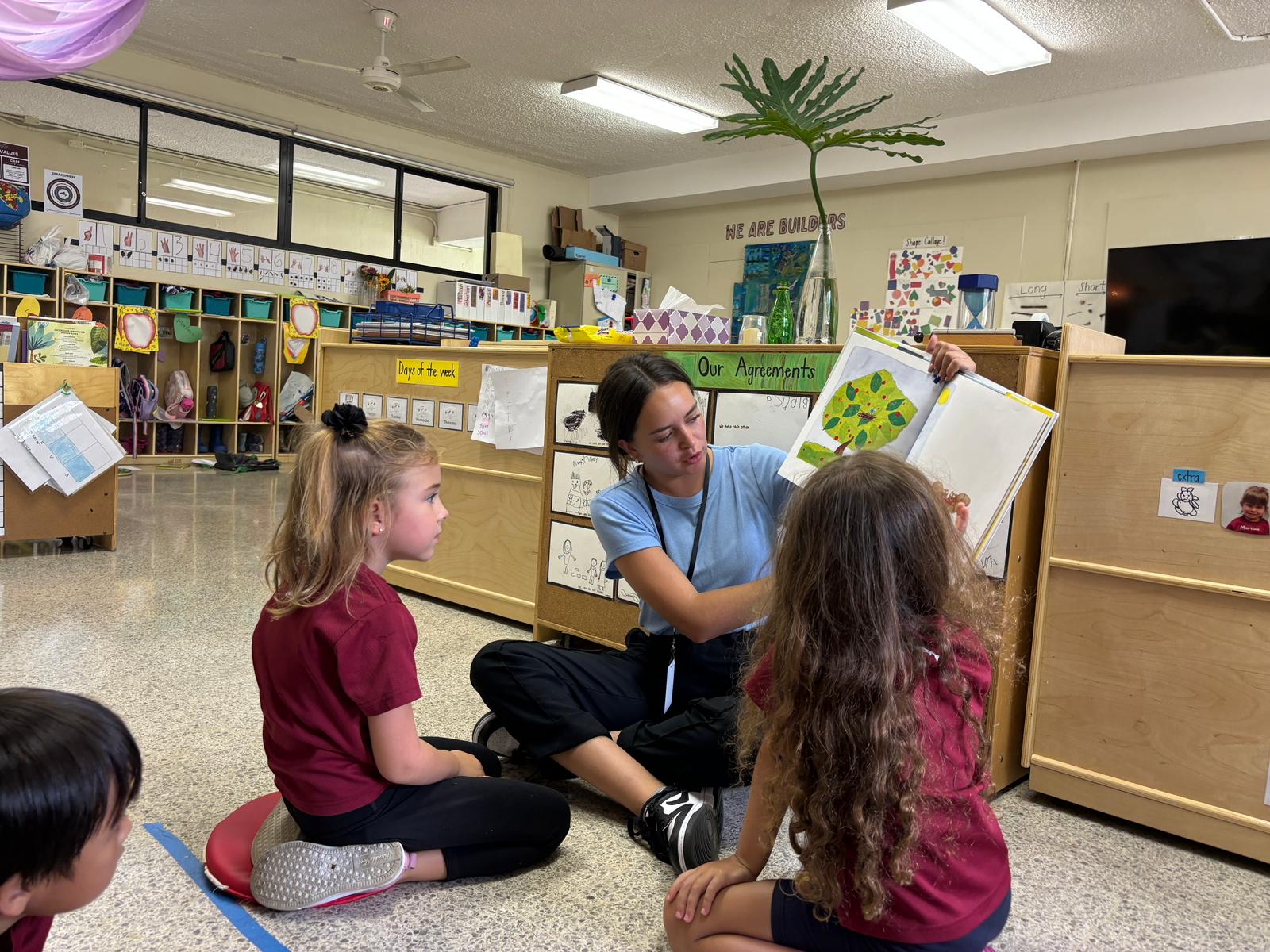 A woman teaches two children.