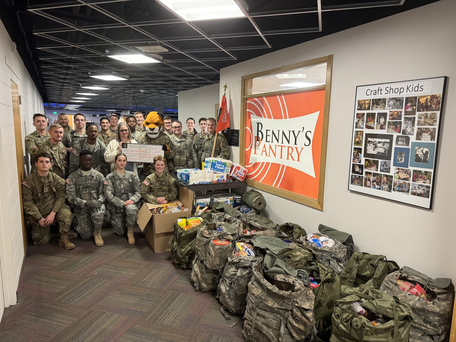 A group of students stand next to a large pile of donations.