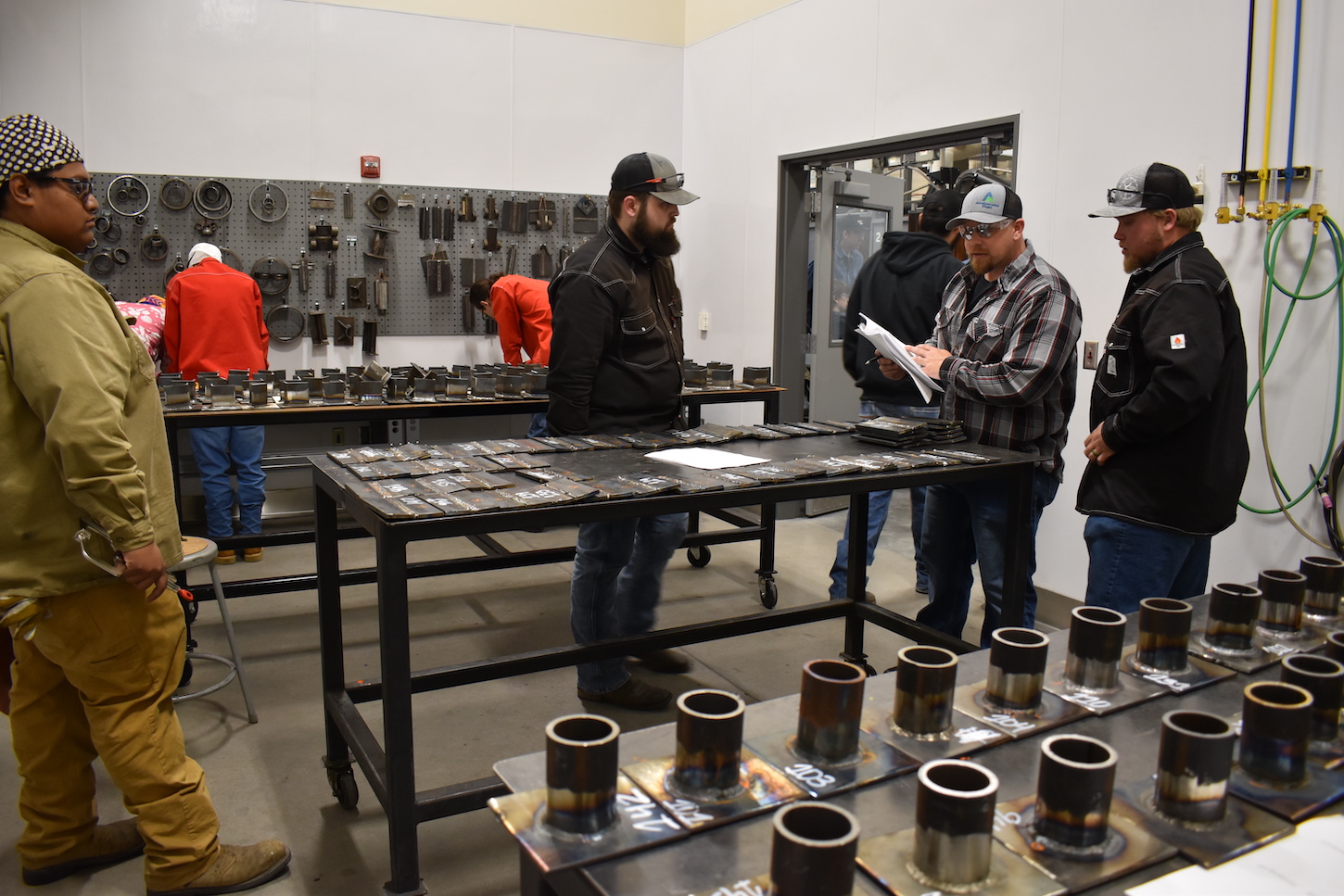 A man looks at welds on a table