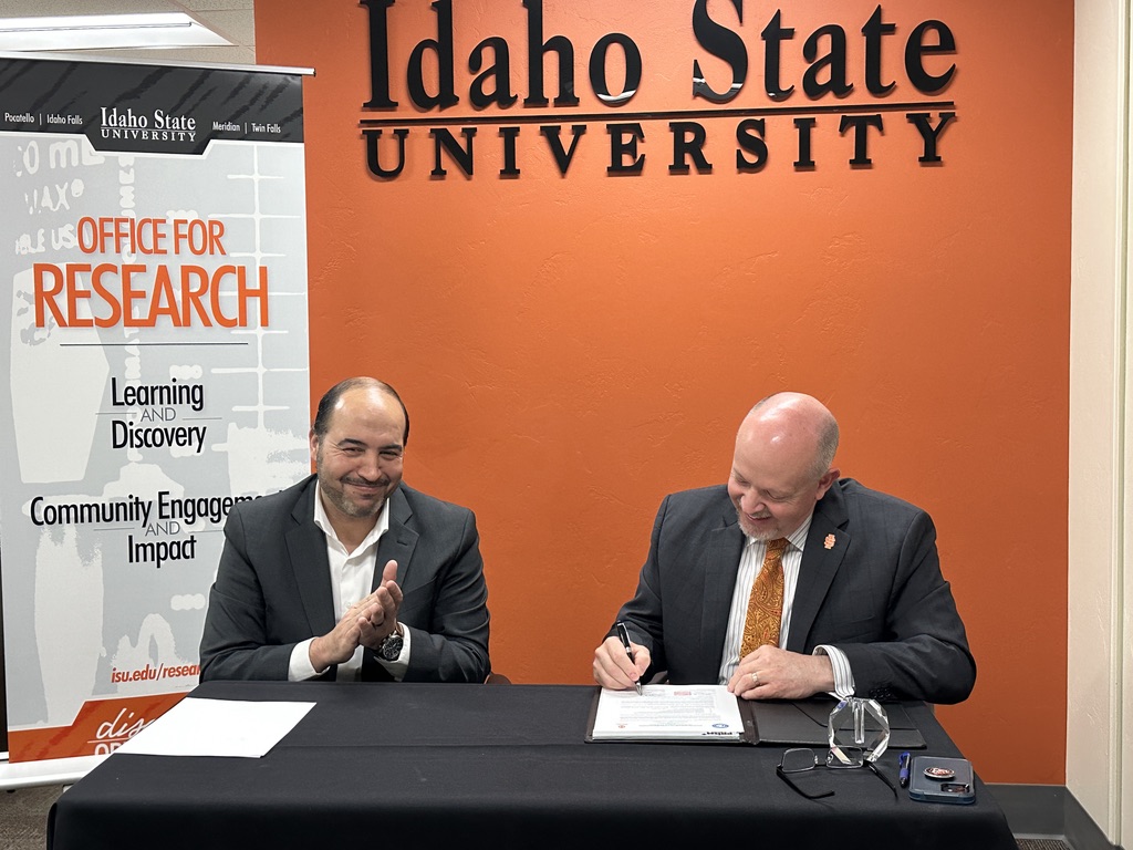 Left, Amir Ali, associate professor of nuclear engineering at Idaho State University, looks on as Marty Blair, vice president for research and economic development, signs a memorandum of understanding between ISU and Gachon University in South Korea.