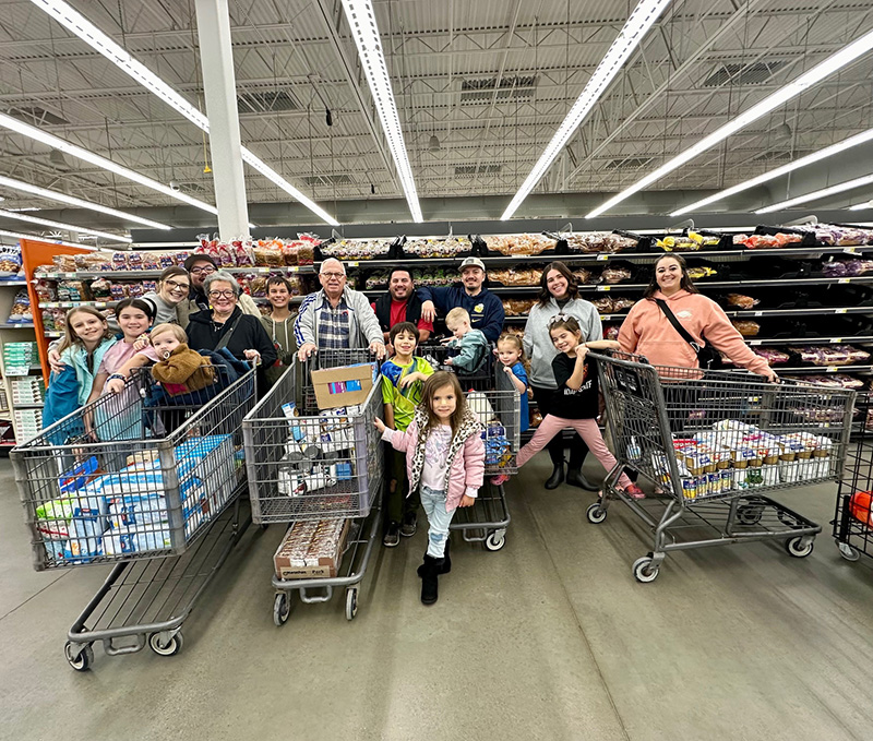 A group stands in front of the bread aisle at Winco in Pocatello with shopping carts full of food for Benny's Giving Tree donations