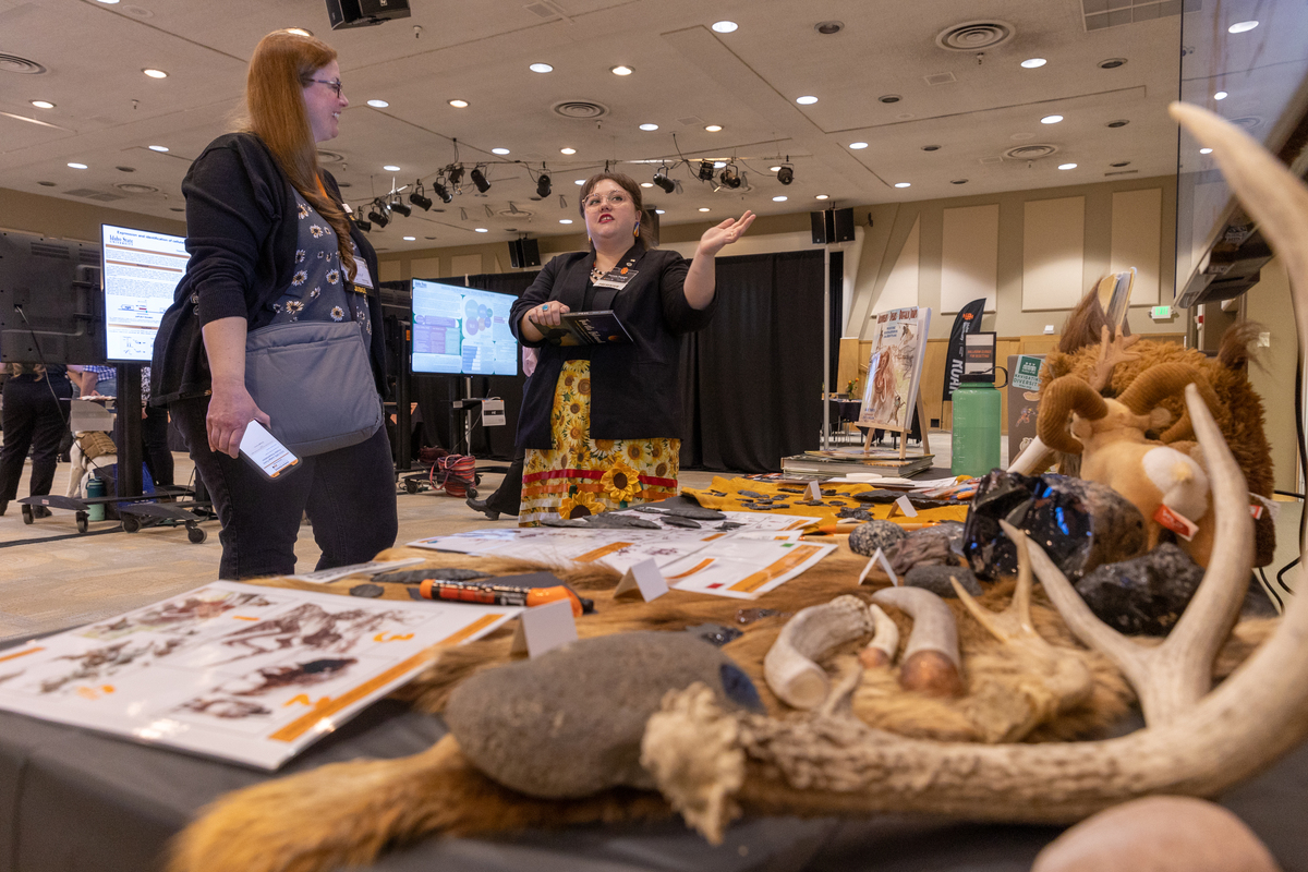 Participants interact while viewing an anthropology exhibit at the Graduate Research Symposium