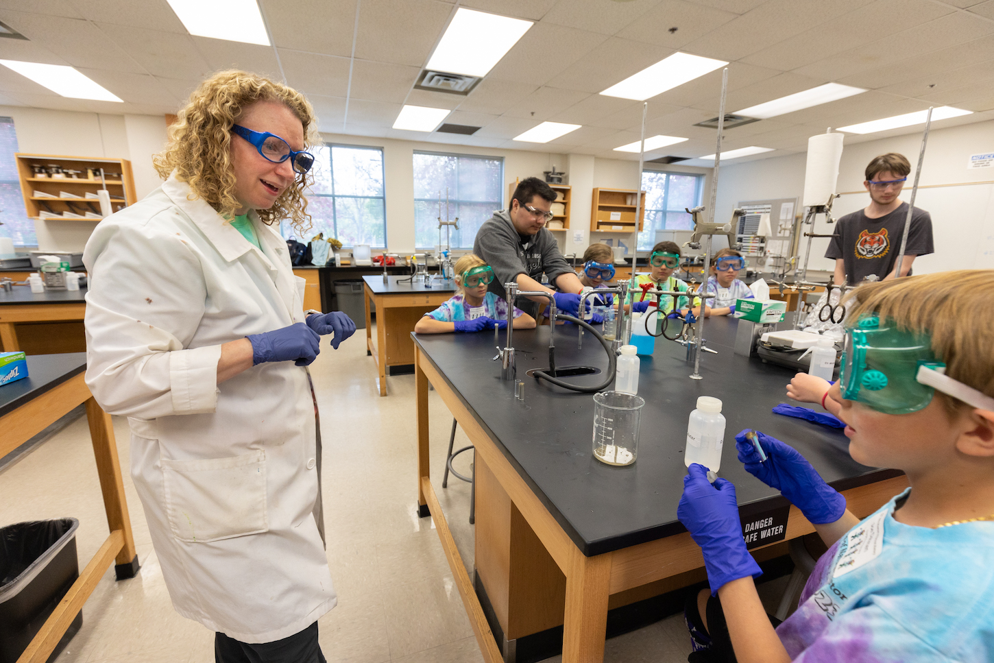 A woman in a lab coat talks with a child