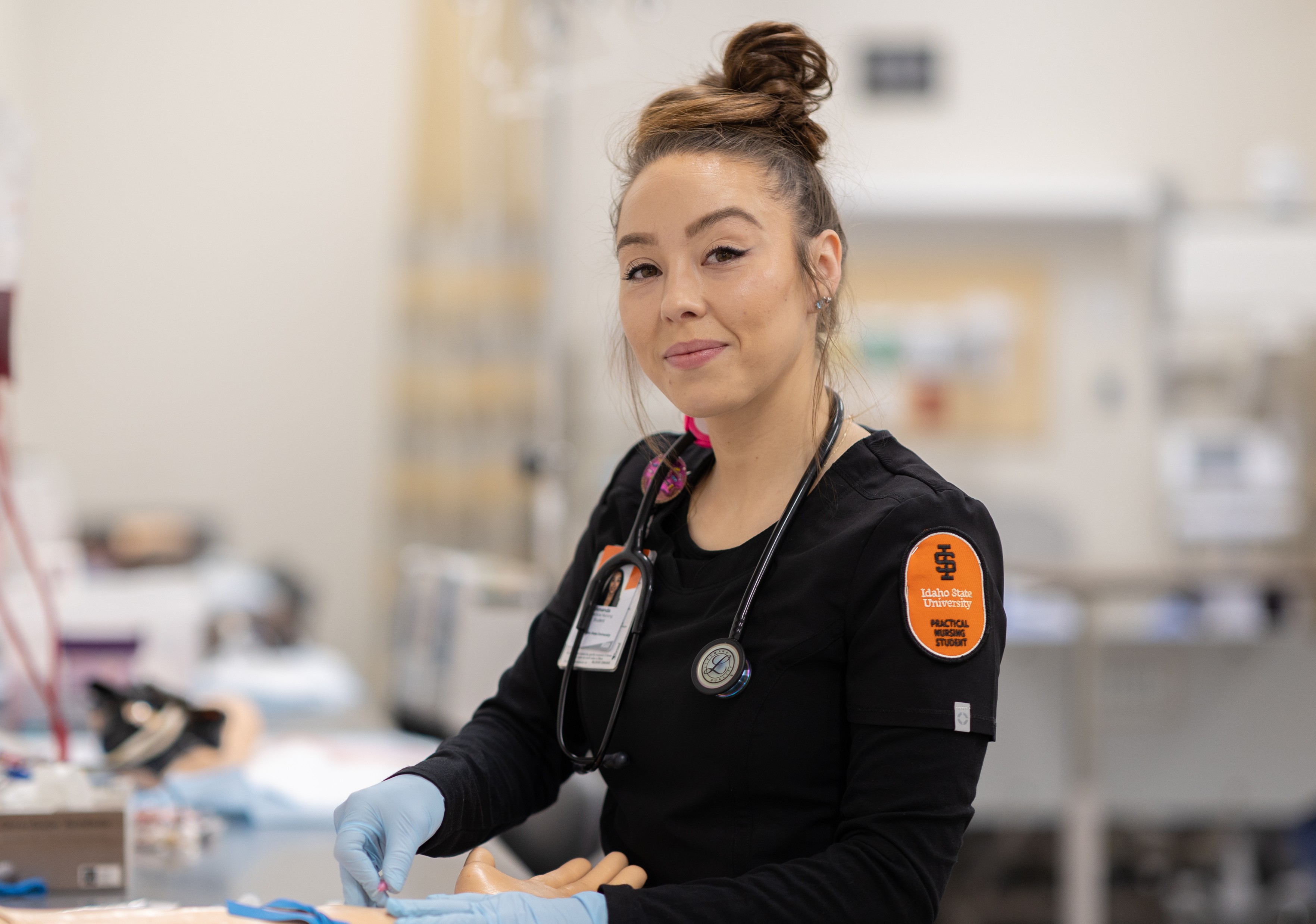 A woman places an IV in a fake arm