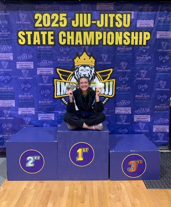 A woman sits on a medals podium