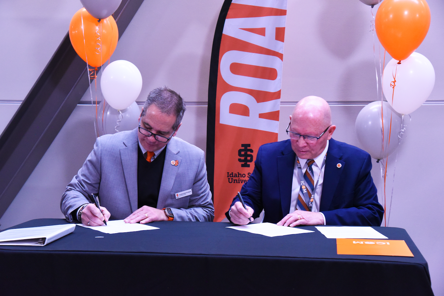 Two men sign a paper