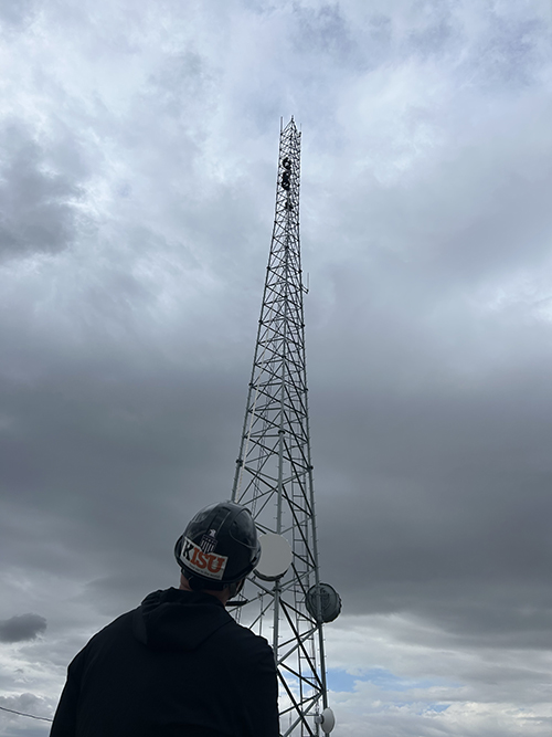 Jamon Anderson holds a rope as an antenna is lifted onto the KISU broadcasting tower