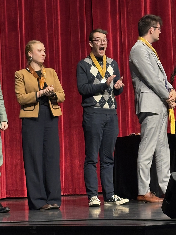 Debate team members on stage at a competition