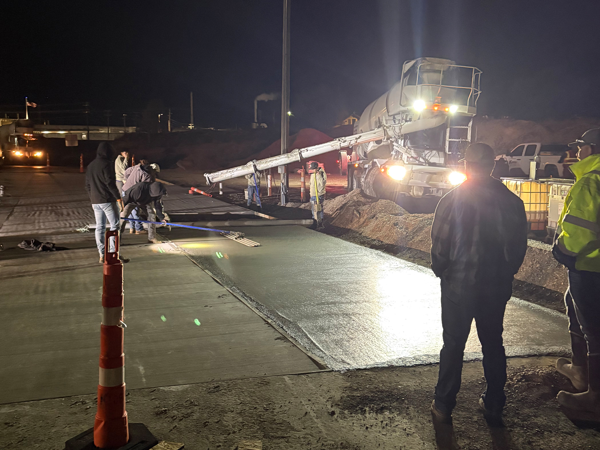 Crew members perform finishing work on the first Sweetcrete pad. This innovative concrete blend uses less cement and is cheaper to produce while still being as strong as conventional concrete developed at Idaho State University.