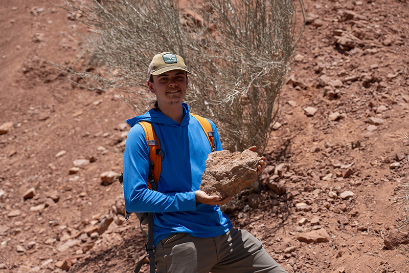 Parker Hazelbush shows off a specimen of Mesozoic crinoid fossils.