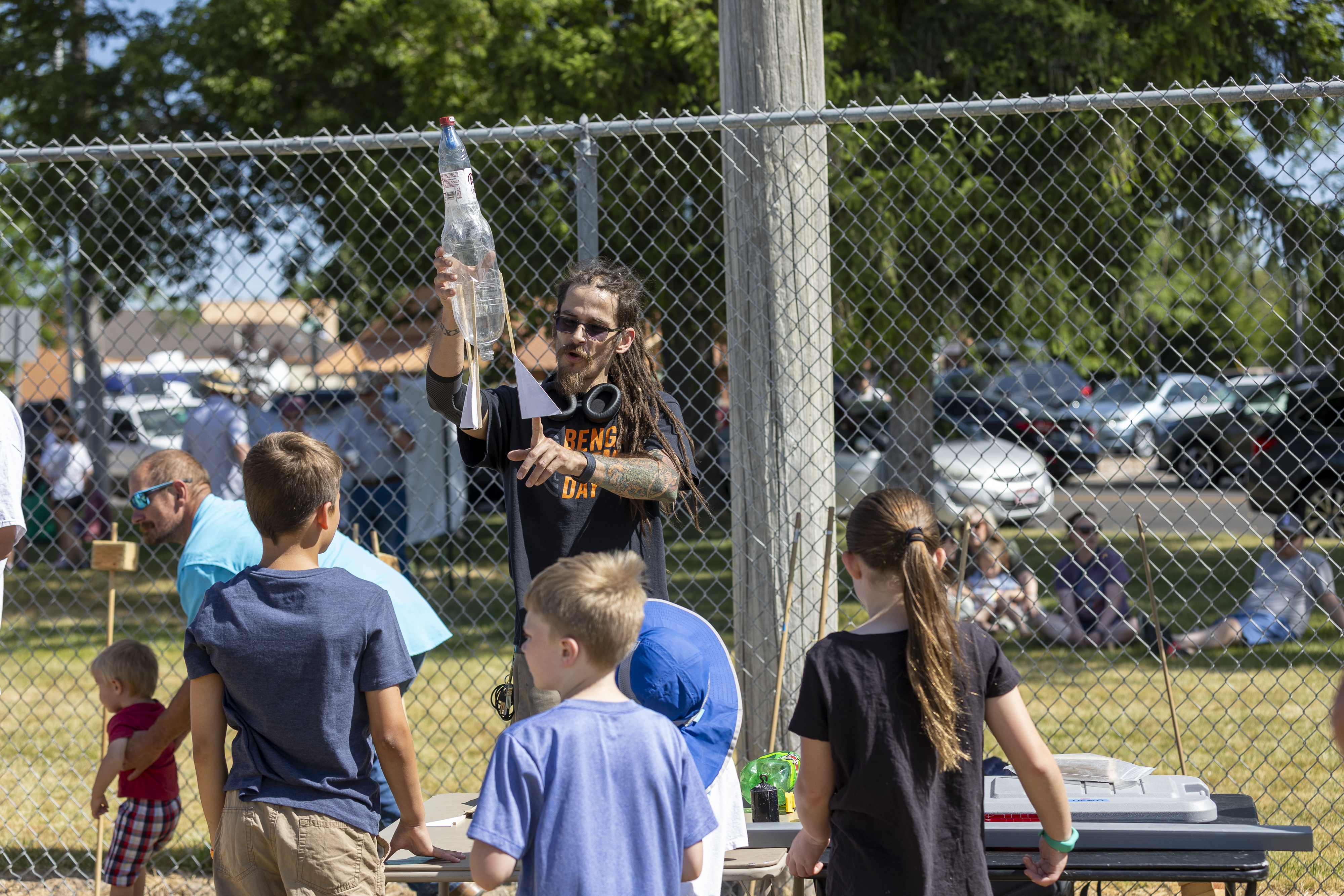 A volunteer helps water rocket scientists build their water rocket.