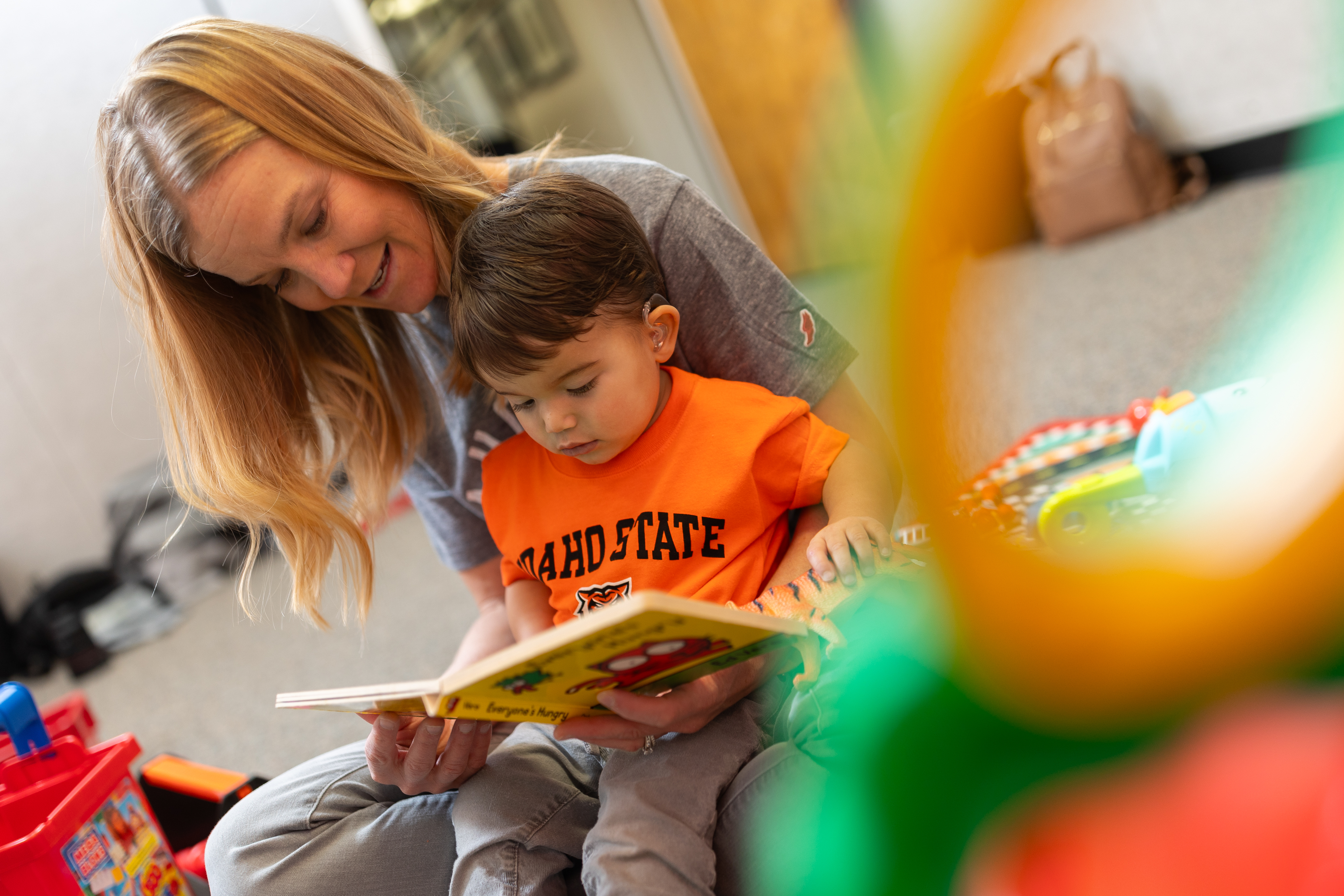 Child with cochlear implants reads with his mother
