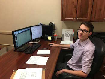 Photo of Alan Carlson sitting in front of computers.