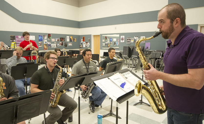 A photo of Armstrong playing saxophone in front of students.