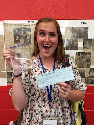 Murdock displaying her trophy and award check.