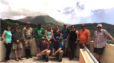 Photo of Idaho State University geosciences students who went to tiny Caribbean island of Montserrat. In the background is a volcano in the distance.