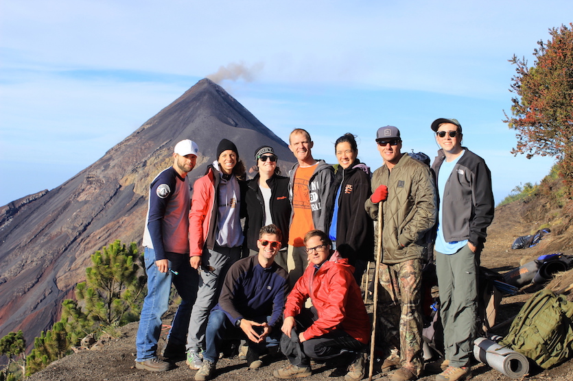 Students in Guatemala with a volcano in the background.