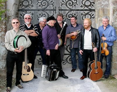 Photo of the band Irish Rovers posing on stage.