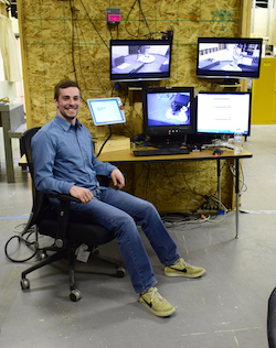 Photo of person monitoring robot from computer screens.