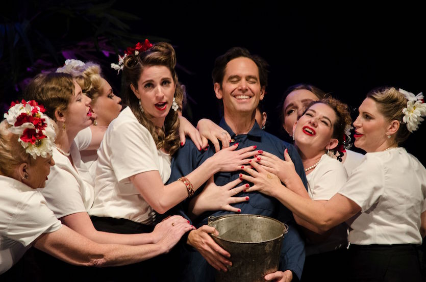 Elixir of Love opera promo picture of man in middle surrounded by women.