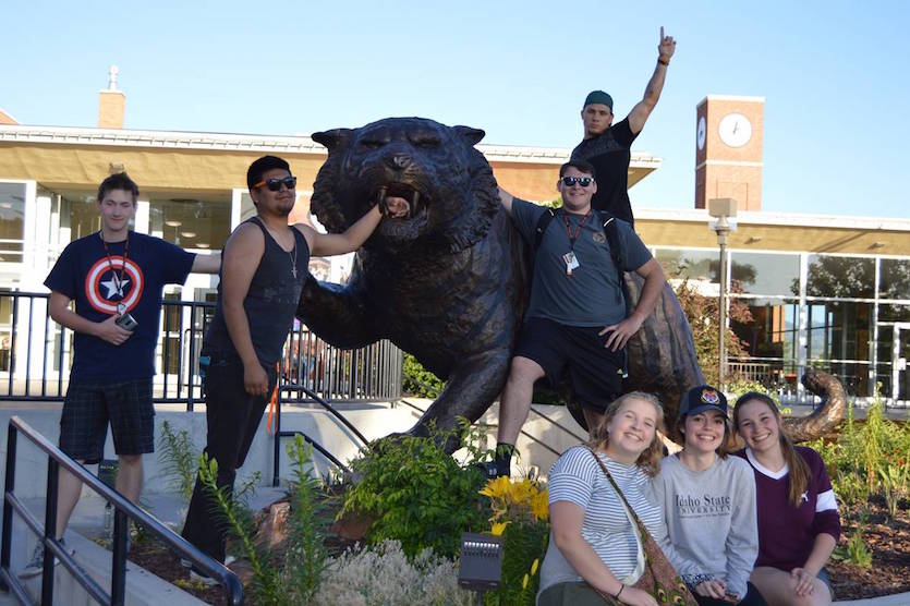 Photo of former Bengal Bridge participants near the statue of the Bengal outside of the Pond Student Union.