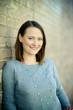 Photo of Bethany Schultz Hurst leaning against a wall. 