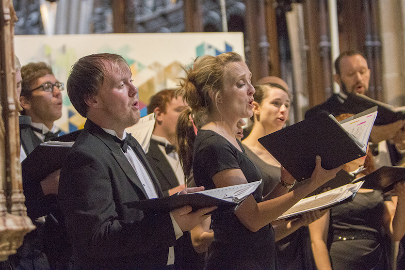 Photo of four choir singers performing on stage.