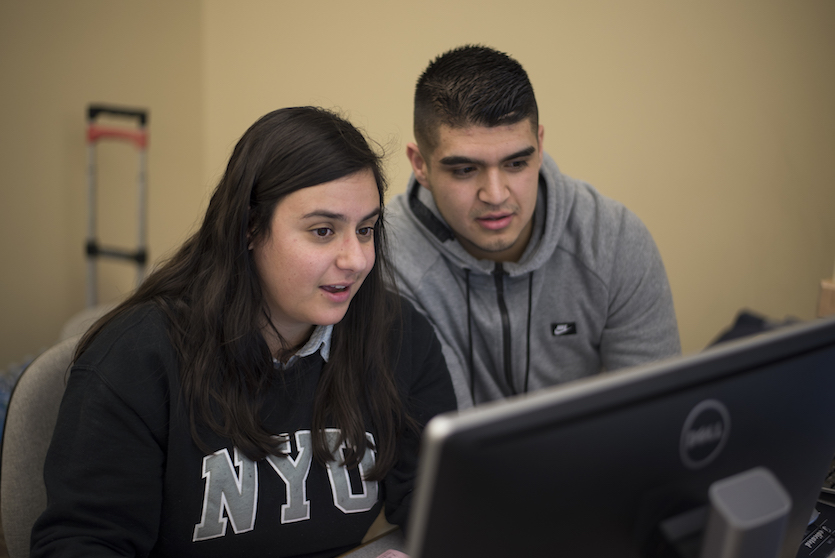 Photo of two students at computer working on taxes. 