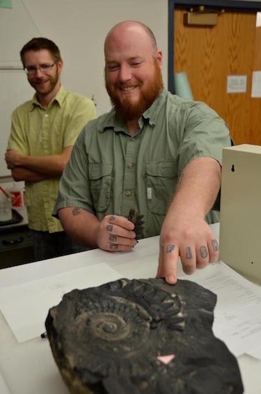 Tapanila and Pruitt with a fossil in the foreground.