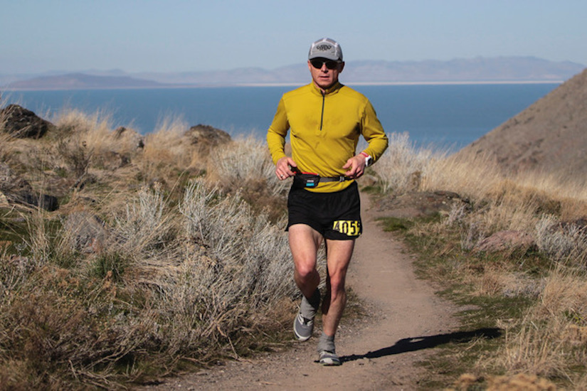 Photo of Shawn Bearden running on trail with ocean in background.